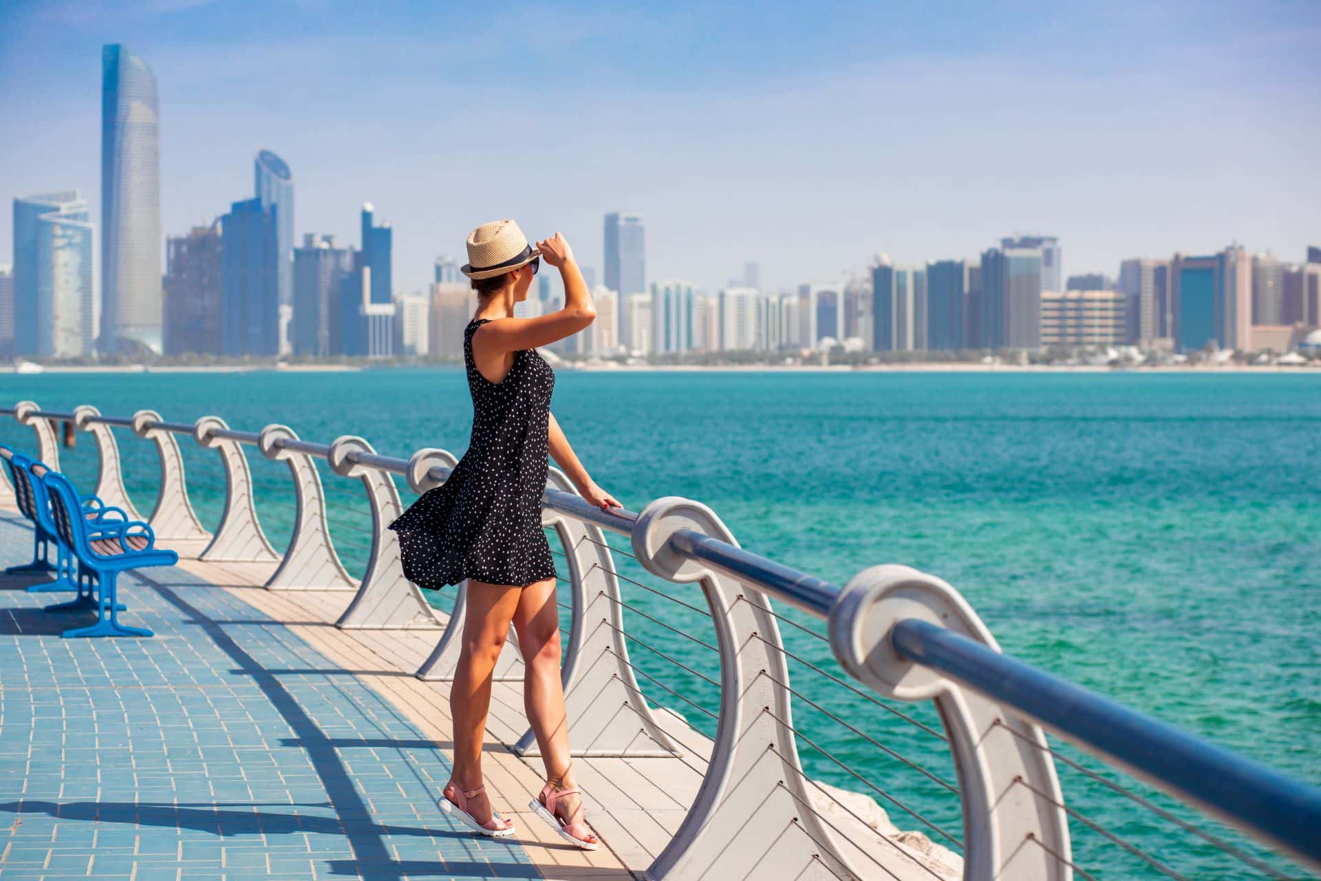 Frau in Sommerkleid genießt die Skyline von Abu Dhabi.